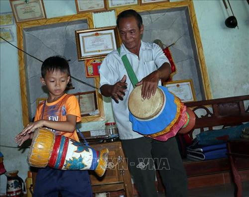 Ông Danh Bê và cháu ngoại Danh Huỳnh Thi (8 tuổi) tập trống. Ảnh: Lê Sen - TTXVN Ông Danh Bê và cháu ngoại Danh Huỳnh Thi (8 tuổi) tập trống. Ảnh: Lê Sen - TTXVN