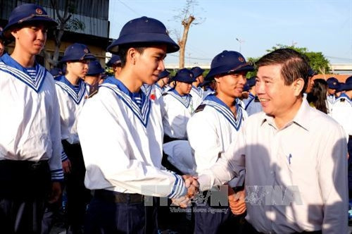 Chủ tịch UBND Thành phố Hồ Chí Minh Nguyễn Thành Phong chúc mừng và động viên các thanh niên trúng tuyển NVQS tại điểm giao quân Quận 9, Thành phố Hồ Chí Minh. Ảnh: Thế Anh - TTXVN