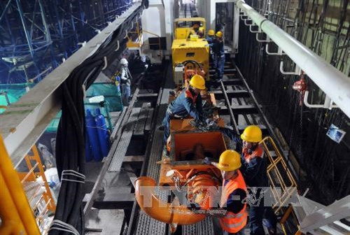 Hệ thống thiết bị khoan ngầm TBM có tổng chiều dài 70m và cân nặng 300 tấn, trong đó đầu máy khoan chính có chiều dài 12,5m, phần còn lại là buồng máy, buồng điều khiển, buồng cung cấp vữa xi măng...Ảnh: An Hiếu - TTXVN Hệ thống thiết bị khoan ngầm TBM có tổng chiều dài 70m và cân nặng 300 tấn, trong đó đầu máy khoan chính có chiều dài 12,5m, phần còn lại là buồng máy, buồng điều khiển, buồng cung cấp vữa xi măng...Ảnh: An Hiếu - TTXVN