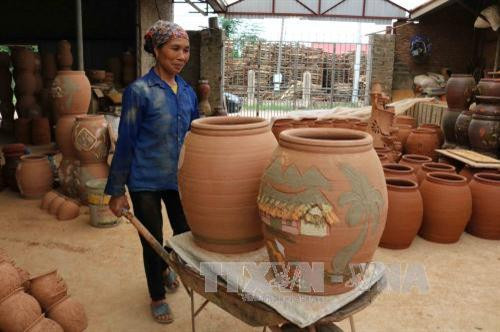 Chum gốm được chuyển vào lò nung. Ảnh: Thanh Thương - TTXVN Chum gốm được chuyển vào lò nung. Ảnh: Thanh Thương - TTXVN