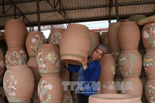 Chum gốm được chuyển vào lò nung. Ảnh: Thanh Thương - TTXVN Chum gốm được chuyển vào lò nung. Ảnh: Thanh Thương - TTXVN