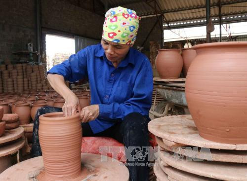 Tạo hình lọ gốm. Ảnh: Thanh Thương - TTXVN Tạo hình lọ gốm. Ảnh: Thanh Thương - TTXVN