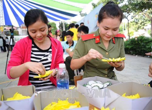 Các thanh niên tham gia tạo hình hoa hướng dương tại ngày hội. Ảnh: An Hiếu – TTXVN
