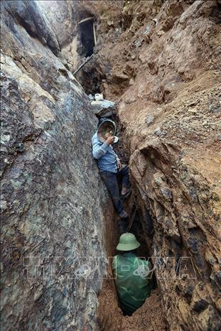 Để đào được những viên đá nghi có vàng, các "Phu vàng" phải chui vào khe núi nhỏ chỉ vừa một người. Ảnh: Phan Tuấn Anh – TTXVN