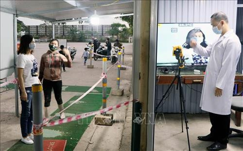 Mọi người dân và du khách được đo thân nhiệt trước khi vào hoặc ra khỏi vùng biên giới Móng Cái. Ảnh: Văn Đức - TTXVN Mọi người dân và du khách được đo thân nhiệt trước khi vào hoặc ra khỏi vùng biên giới Móng Cái. Ảnh: Văn Đức - TTXVN