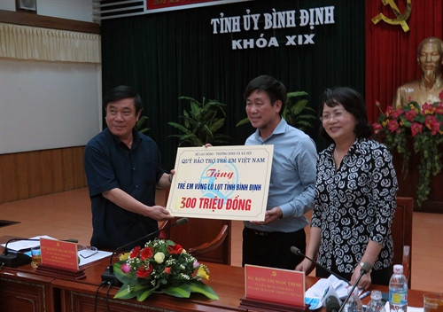 Chiều 20-12, Đoàn công tác Văn phòng Chủ tịch nước do Phó Chủ tịch nước Đặng Thị Ngọc Thịnh dẫn đầu, đã tới thăm và tặng quà người dân vùng rốn lũ xã Phước Hòa, huyện Tuy Phước, tỉnh Bình Định. Phó Chủ tịch nước đã tặng 20 suất quà cho người dân huyện Tuy Phước bị sập nhà do lũ lụt, mỗi suất trị giá 10 triệu đồng và trao tặng cho trẻ em vùng lũ Bình Định 300 triệu đồng để mua sách vở, giúp các em tiếp tục đến trường. Trong ảnh: Phó Chủ tịch nước Đặng Thị Ngọc Thịnh trao tặng cho trẻ em vùng lũ Bình Định 300 triệu đồng để mua sách vở. Ảnh: Viết Ý-TTXVN