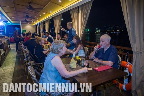 Du khách nước ngoài trải nghiệm du lịch đường sông nội đô kết hợp phục vụ ẩm thực về đêm tại bến Bạch Đằng (quận 1. TP.HCM)