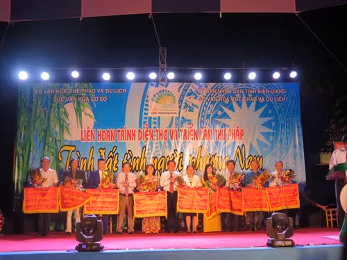 Ông Huỳnh Vĩnh Ái tặng hoa và cờ lưu niệm cho các đoàn tham dự đêm trình diễn thơ