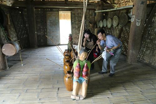 Khách tham quan thích thú trải nghiệm các hoạt động đời sống của người Gia Rai. Ảnh: Nam Sương