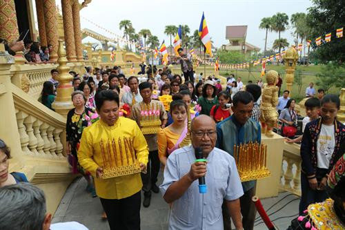 Mọi người cùng xếp hàng đi vòng quanh chánh điện 3 vòng để làm Lễ chào mừng năm mới. Ảnh: Nam Sương