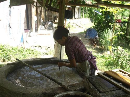 Phần vỏ cây sau khi đập nát được cho xuống bể nước quấy đều.