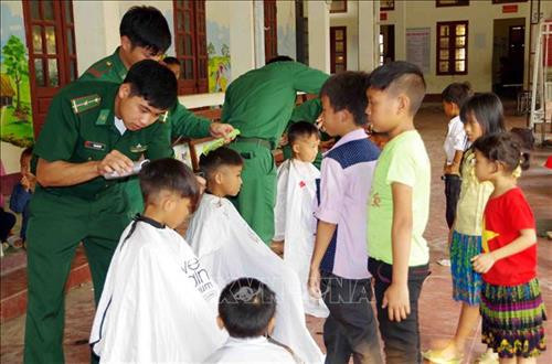 Cán bộ, chiến sỹ Đồn Biên phòng Pa Tần cắt tóc cho các em học sinh trường Tiểu học Pa Tần. Ảnh: Công Tuyên - TTXVN