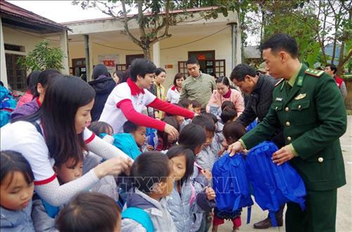 Các chiến sĩ Đồn Biên phòng Pa Tần tặng quà cho các em học sinh tại điểm trường trên địa xã biên giới Pa Tần (Sìn Hồ, Lai Châu). Ảnh: Công Tuyên - TTXVN