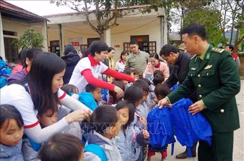 Các chiến sĩ Đồn Biên phòng Pa Tần tặng quà cho các em học sinh tại điểm trường trên địa xã biên giới Pa Tần (Sìn Hồ, Lai Châu). Ảnh: Công Tuyên - TTXVN