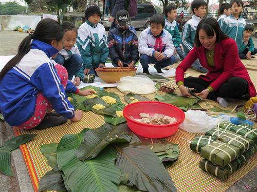 Các em thiếu nhi cũng được tham gia học và gói bánh chưng. Ảnh: Lâm Khánh - TTXVN