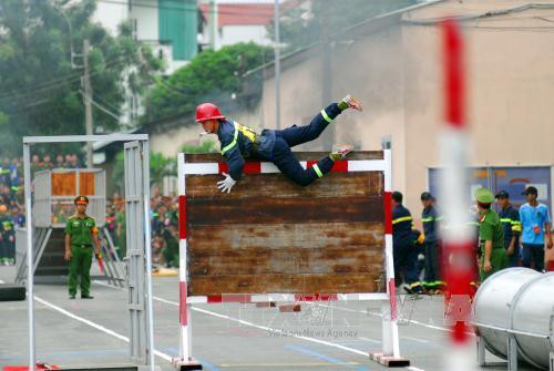 Phần thi chạy 4x100m vượt chướng ngại vật cứu nạn, cứu hộ. Ảnh: Mạnh Linh – TTXVN