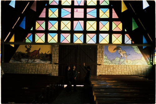 Nhà thờ Cam Ly hay còn gọi là nhà thờ Sơn Cước (đường Nguyễn Khuyến, phường 5, TP Đà Lạt) vừa cổ kính vừa mang trong mình câu chuyện riêng. Nhà thờ này đã được xây dựng và tồn tại 50 năm, trong quá trình hình thành gặp vô vàn khó khăn. Trước đây nhà thờ Cam Ly dành cho đồng bào dân tộc (chủ yếu là người K’ho) nhưng giờ mở rộng ra cho mọi người. Trước cổng nhà thờ có hình hổ và đại bàng, tượng trưng cho sức mạnh, sự bảo vệ và vươn xa. Đường dẫn vào nhà thờ tràn ngập những loài hoa nhỏ xinh. Mái công được xây bằng loại gạch màu cũ xưa theo hình nhà tháp, giống cấu trúc nhà rông của đồng bào Tây Nguyên. Khi bước vào trong nhà thờ, bạn sẽ nhận thấy tràn ngập màu sắc với hình tam giác và hình chữ nhật. Người ta quan niệm hình tam giác tượng trưng cho Yàng - đấng tối cao của đồng bào, cũng là chúa Jesus. Hình vuông là quan niệm vũ trụ, trái đất là trung tâm và mọi thứ xoay quanh Trái đất. Phần đầu của nhà thờ cũng được xây dựng trong các khung hình màu sắc, hình Cha đặt làm trung tâm. Điều đặc biệt là trong nhà thờ này, dưới bức tượng của Cha, người ta đặt một cái đầu trâu với ý nghĩa trâu là loài động vật lành tính, siêng năng và trung thành, mong con người cũng hướng về những điều đó. Hơn 60 em nhỏ đang được nuôi dạy tại đây, có em mồ côi, có em được mẹ gửi vào. Mỗi ngày các em vui chơi, học tập, chiều đến thì vào nhà thờ đọc kinh. Nhà thờ Cam Ly không được nhiều người biết đến, bởi con người ở đây cũng sống tương đối ẩn dật. Mang trong mình nét màu sắc kiến trúc riêng, những thiết kế, trưng bày đều mang ý nghĩa riêng, nhà thờ Cam Ly vừa cũ vừa mới lại vừa ấm áp tình người. Nhà thờ Cam Ly (chấm đỏ) trên bản đồ. Ảnh: Google Map.