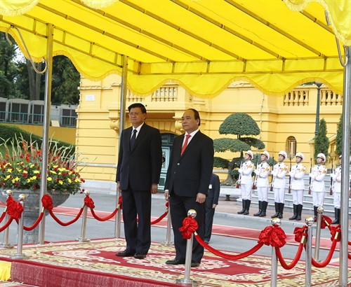 Nhận lời mời của Thủ tướng Chính phủ Nguyễn Xuân Phúc, Thủ tướng Chính phủ nước Cộng hòa Dân chủ Nhân dân Lào Thongloun Sisoulith và Phu nhân cùng Đoàn đại biểu cấp cao Chính phủ nước CHDCND Lào thăm hữu nghị chính thức Việt Nam từ ngày 15 – 17/5/2016. Trong ảnh: Thủ tướng Chính phủ Nguyễn Xuân Phúc và Thủ tướng Chính phủ nước Cộng hòa Dân chủ Nhân dân Lào Thongloun Sisoulith tại lễ đón. Ảnh: Thống Nhất-TTXVN