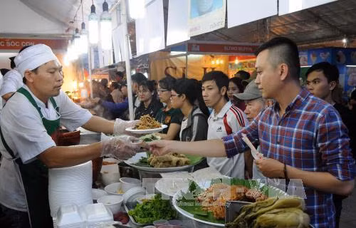 Khách thưởng thức món ăn tại gian hàng ẩm thực của Liên hoan ẩm thực món ngon các nước lần thứ 11. Ảnh: An Hiếu - TTXVN