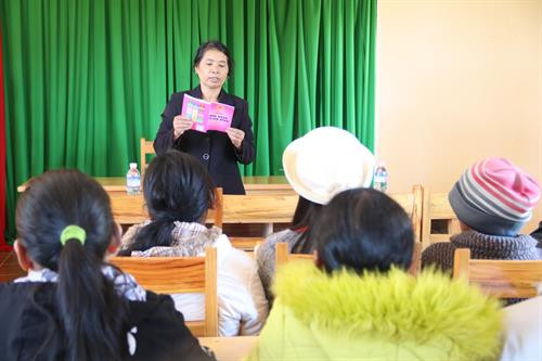 Bà Kim Hoa, cựu Bí thư Chi bộ thôn Tu Pó nói chuyện, tuyên truyền với bà con về chấp hành luật Hôn nhân và gia đình. Ảnh: Nam Sương - TTXVN