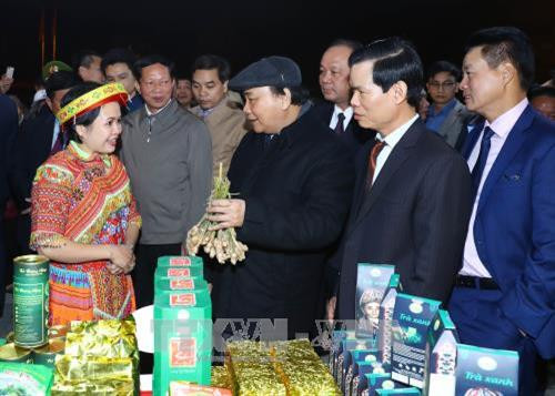 Thủ tướng Nguyễn Xuân Phúc xem và nghe giới thiệu sản phẩm tiêu biểu được trưng bày. Ảnh: Thống Nhất –TTXVN