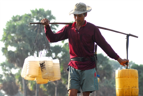Anh Chau Chun (xã Văn Giáo, huyện Tinh Biên) gánh nước thốt nốt về nhà để nấu đường.