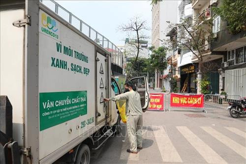 Nhân viên Công ty Môi trường đến vận chuyển rác thải cho các hộ dân sống trong khu vực cách ly. Ảnh: Thành Đạt - TTXVN