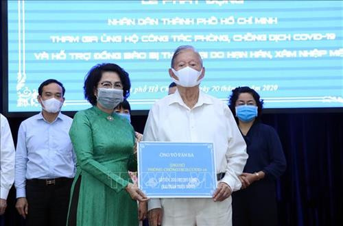Tiếp nhận tượng trưng số tiền ủng hộ từ ông Võ Văn Ba, một người dân Thành phố Hồ Chí Minh. Ảnh: Xuân Khu-TTXVN