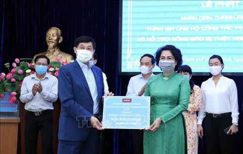 Tiếp nhận tượng trưng số tiền ủng hộ công tác phòng chống dịch COVID-19 của ông Jonathan Hạnh Nguyễn, Chủ tịch Tập đoàn Liên Thái Bình Dương. Ảnh: Xuân Khu-TTXVN