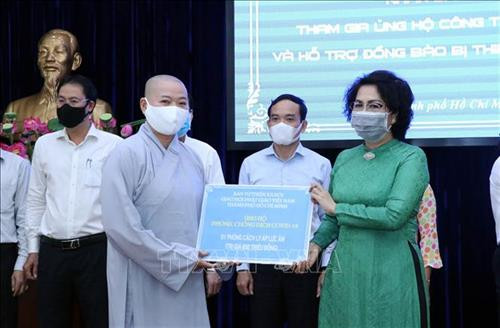 Tiếp nhận tượng trưng số tiền ủng hộ từ Ban Từ thiện-Xã hội, Giáo hội Phật giáo Việt Nam Thành phố Hồ Chí Minh. Ảnh: Xuân Khu-TTXVN
