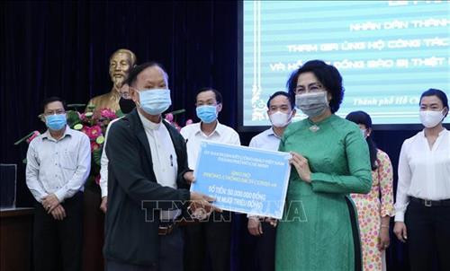 Tiếp nhận tượng trưng số tiền ủng hộ của Ủy ban Đoàn kết Công giáo Việt Nam Thành phố Hồ Chí Minh. Ảnh: Xuân Khu-TTXVN