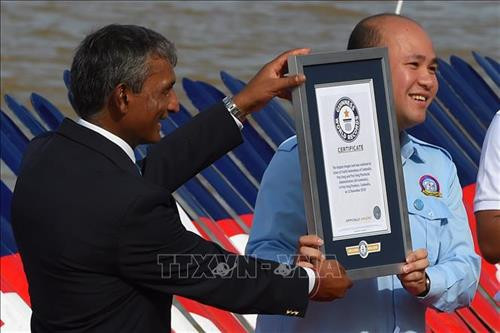 Đại diện Tổ chức Kỷ lục Guinness thế giới Patel P. Jasmatbhai (trái) trao chứng nhận về chiếc Ghe Ngo dài nhất thế giới cho đại diện Campuchia tại Prey Veng ngày 12/11/2018. Ảnh: AFP/ TTXVN