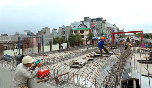 Thi công hạng mục đường dẫn 2 đầu cầu vượt nút giao Cổ Linh - đường dẫn cầu Vĩnh Tuy. Ảnh: Huy Hùng – TTXVN