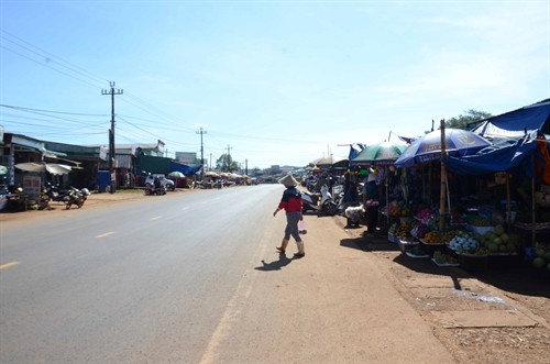 Nhiều hộ tiểu thương kinh doanh ở chợ tạm Quảng Tín lấn chiếm hành lang đường Hồ Chí Minh, gây mất an toàn giao thông