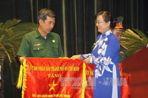 Chủ tịch HĐND Thành phố Hồ Chí Minh Nguyễn Thị Quyết Tâm trao tặng Cờ thi đua của UBND Thành phố cho các tập thể đạt nhiều thành tích trong phong trào thi đua yêu nước năm 2016. Ảnh: Thanh Vũ-TTXVN