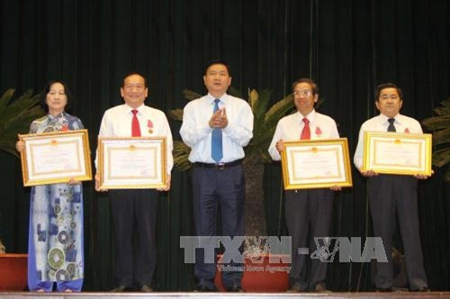 Bí thư Thành ủy Đinh La Thăng trao tặng Huân chương Lao động hạng Nhất, hạng Ba của Chủ tịch nước cho các cá nhân có thành tích xuất sắc trong phong trào thi đua yêu nước. Ảnh: Thanh Vũ-TTXVN