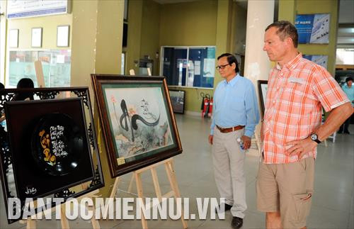 Du khách quốc tế xem các tác phẩm tranh thư pháp tại triển lãm