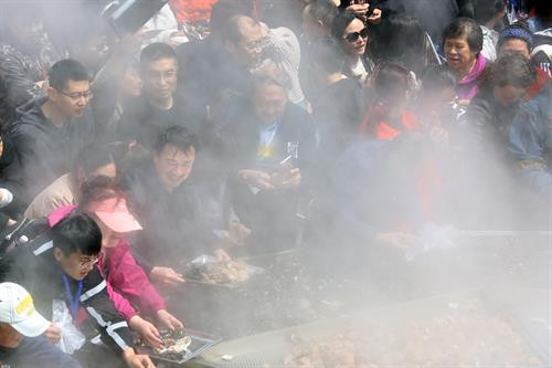 Người dân thưởng thức món hải sản trên chiếc vạc khổng lồ tại lễ hội. THX/TTXVN