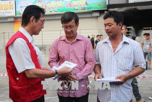 Đại diện Trung ương Hội Chữ thập đỏ Việt Nam trao hỗ trợ cho gia đình nạn nhân. Ảnh: Xuân Dự - TTXVN