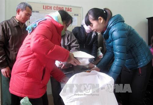 Bà con nhận gạo hỗ trợ. Ảnh: TTXVN Bà con nhận gạo hỗ trợ. Ảnh: TTXVN