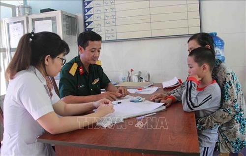 Các y, bác sỹ Bệnh xá Quân dân y 737 cấp thuốc miễn phí, hướng dẫn cho người nghèo trong xã Ia R’vê cách sử dụng thuốc. Ảnh: Phạm Cường-TTXVN