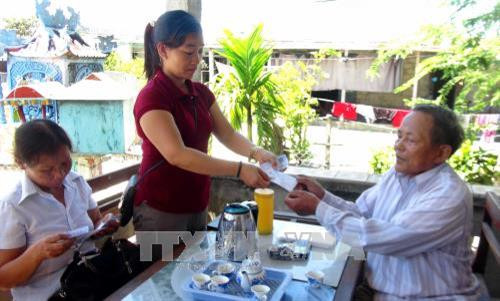 Nhân viện đại lý thu bảo hiểm y tế đến từng từng hộ dân để tuyên truyền và cấp thẻ bảo hiểm y tế. Ảnh: Tường Vi - TTXVN. Nhân viện đại lý thu bảo hiểm y tế đến từng từng hộ dân để tuyên truyền và cấp thẻ bảo hiểm y tế. Ảnh: Tường Vi - TTXVN.