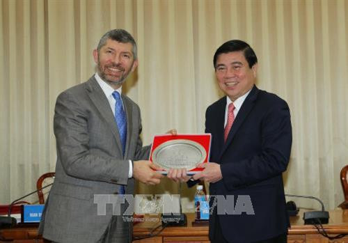 Chủ tịch UBND Thành phố Hồ Chí Minh Nguyễn Thành Phong tặng quà lưu niệm cho Thứ trưởng Bộ Phát triển Kinh tế Italia, ông Ivan Scalfarotto. Ảnh: Thanh Vũ-TTXVN