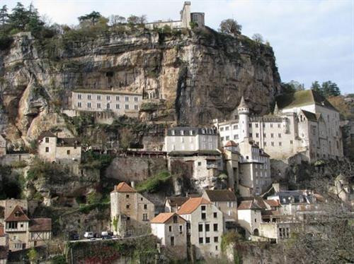 Ngôi làng cổ Rocamadour được xây dựng trên vách núi ở vùng Occitanie, miền tây nam Pháp. Từ thời Trung cổ, ngôi làng đã thu hút những người hành hương từ khắp châu Âu tới đây tham quan các công trình lịch sử và nhà thờ Đức Mẹ Maria. Thánh St Amator đã sống và qua đời tại ngôi làng Rocamadour ngay sau khi ông rời khỏi Jerusalem. Truyền thuyết kể rằng sau khi thi thể thánh St Amator được phát hiện, một số phép màu đã xảy ra. Ngôi làng bắt đầu thu hút nhiều người hành hương và ủng hộ từ các nhà vua Pháp, giúp ngôi làng xây dựng các nơi thờ cúng. Một lý do khác khiến Rocamadour thu hút nhiều du khách là phong cảnh đẹp. Các công trình cổ được xây dựng trên vách núi nhìn xuống sông Alzou. Các tòa nhà trong làng có độ cao cách mặt đất phía dưới khoảng 120m. Trung tâm của ngôi làng là nhà thờ hành hương Notre Dame, được cải tạo lại từ công trình gốc được xây dựng từ năm 1479. Ngoài ra, Rocamadour còn có nhiều công trình cổ kính khác được xây dựng từ thời Trung cổ. Du khách tham quan dọc một con đường dốc tại ngôi làng cổ Rocamadour. Những ngôi nhà được xây dựng trên vách đá dựng đứng. Ngôi làng cổ Rocamadour được xây dựng trên vách núi ở vùng Occitanie, miền tây nam Pháp. Từ thời Trung cổ, ngôi làng đã thu hút những người hành hương từ khắp châu Âu tới đây tham quan các công trình lịch sử và nhà thờ Đức Mẹ Maria. Thánh St Amator đã sống và qua đời tại ngôi làng Rocamadour ngay sau khi ông rời khỏi Jerusalem. Truyền thuyết kể rằng sau khi thi thể thánh St Amator được phát hiện, một số phép màu đã xảy ra. Ngôi làng bắt đầu thu hút nhiều người hành hương và ủng hộ từ các nhà vua Pháp, giúp ngôi làng xây dựng các nơi thờ cúng. Một lý do khác khiến Rocamadour thu hút nhiều du khách là phong cảnh đẹp. Các công trình cổ được xây dựng trên vách núi nhìn xuống sông Alzou. Các tòa nhà trong làng có độ cao cách mặt đất phía dưới khoảng 120m. Trung tâm của ngôi làng là nhà thờ hành hương Notre Dame, được cải tạo lại từ công trình gốc được xây dựng từ năm 1479. Ngoài ra, Rocamadour còn có nhiều công trình cổ kính khác được xây dựng từ thời Trung cổ. Du khách tham quan dọc một con đường dốc tại ngôi làng cổ Rocamadour. Những ngôi nhà được xây dựng trên vách đá dựng đứng.