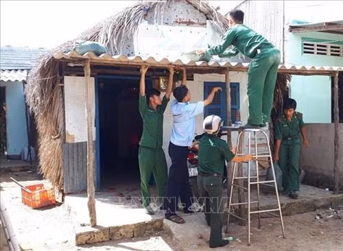 Bộ đội Biên phòng Đồn Long Hòa giúp người dân xã Lý Nhơn lợp lại mái nhà chống bão. Ảnh: TTXVN phát