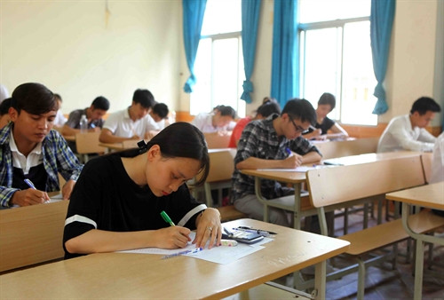 Thí sinh tại cụm thi trường Đại học Vinh trao đổi bài thi sau khi kết thúc môn thi Địa Lý, sáng 3/7. Ảnh: Thanh Tùng- TTXVN