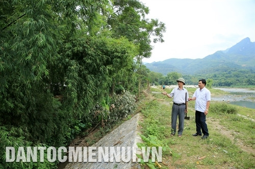Ông Hoàng Đình Thìn (bên trái) trao đổi với cán bộ huyện Văn Chấn tại khu vực thôn An Luông 1, nơi gia đinh ông đã tự nguyện chặt bỏ 2.000 gốc tre để lẫy chỗ thi công kè Suối Thia. Ảnh: Phan Ngọc Đức
