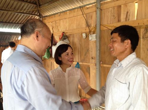 Lê Thị Hương và Giám đốc Ban quản lý Dự án 600 Phó Chủ tịch xã Vũ Đăng Minh trao đổi với anh Lò Văn Khặn. Ảnh: Chu Thanh Vân - TTXVN