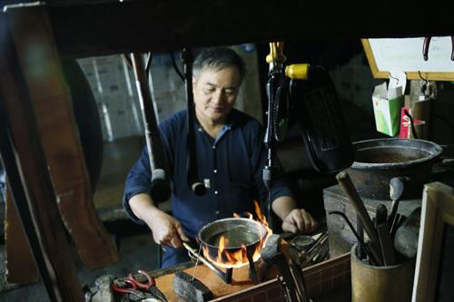 Nghệ nhân đang nấu phèn chua để làm trắng bạc