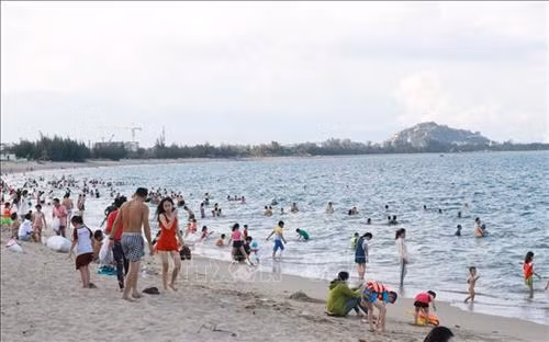 Du khách vui chơi, tắm biển tại bãi biển Bình Sơn (thành phố Phan Rang - Tháp Chàm). Ảnh: Nguyễn Thành - TTXVN